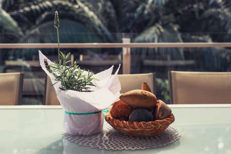 Lavender in a pot covered with a white paper and stone bowl decorations on the table on balcony with...