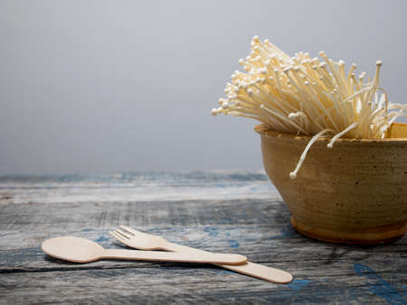 Enoki mushrooms in clay bowl on tableの写真素材