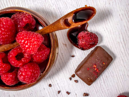 Dark handmade chocolate with raspberries and syrupの写真素材