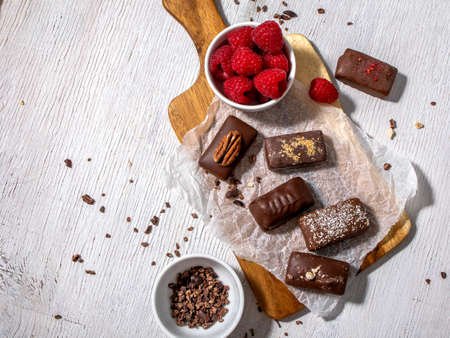 Dark handmade chocolate stack, coconut chips, rasberries and nutsの写真素材