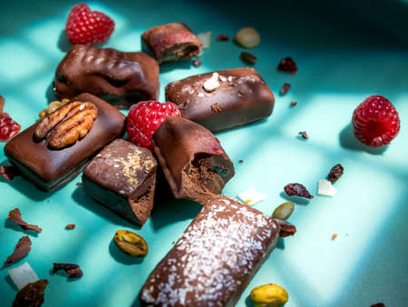 Dark handmade chocolate stack, coconut chips, raspberries and nutsの写真素材