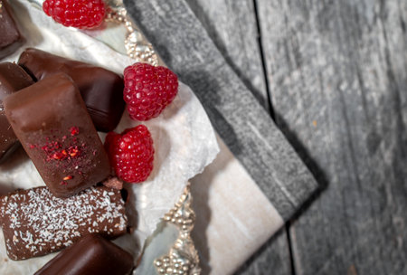 Dark handmade chocolate stack with raspberries and nutsの写真素材