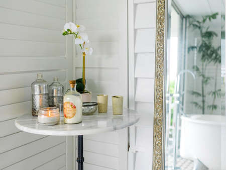 Candles and orchid flowers on the table near mirror in bathroomの写真素材