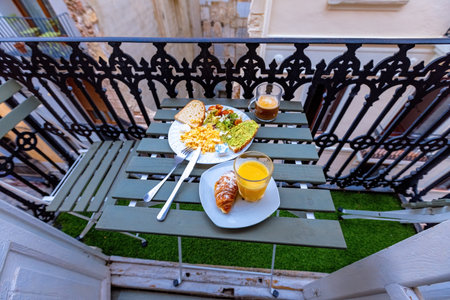 Breakfast with scrabled eggs, coffee, orange juice and avocado toast on the balcony in Spanish old townの写真素材
