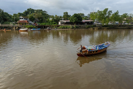 Boatman in traditional boat on Sarawak river in Kuching Borneo Malaysiaのeditorial素材