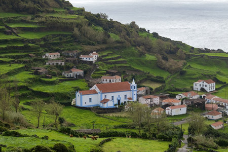 Breathtaking view of the houses on the cliff at Atlantic ocean coast in Azores islands Portugalの写真素材