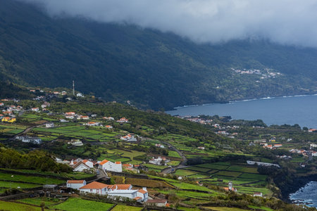 Breathtaking view of the small village and green meadows from the cliff at Pico island Azores Portugalの写真素材