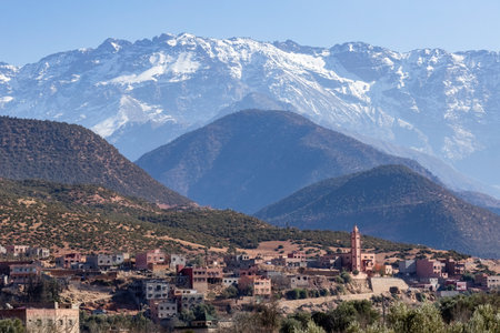 Grand Atlat mountains and Orica valley view with traditional houses and mosque minaret snowy...