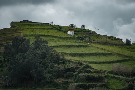Green hills and traditional white houses in Azores islands Portugalの写真素材