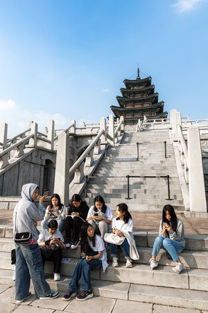 Young people sitting on the stairs of Pagoda building of The National Folk Museum of Korea in Seoul South Korea