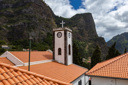 Clock tower and tiled roofs at the small picturesque mountain village Curral das Freiras in Madeira,...