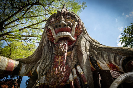 Traditional Balinese guardian statue under tropical trees, capturing the spiritual and artistic heritage of Baliのeditorial素材