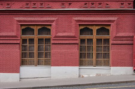 Ancient building of red brick. The lower part of the building is unevenly submerged in the ground. The theory of excavated or buried cities.の写真素材