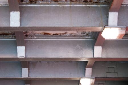 Under the bridge. An element of the street landscape is a view of the construction of the bridge from below. The backlight and structural elements create a visual rhythm. Metal, light, wayの写真素材