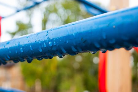 Raindrops on a blue metal pipe.の写真素材
