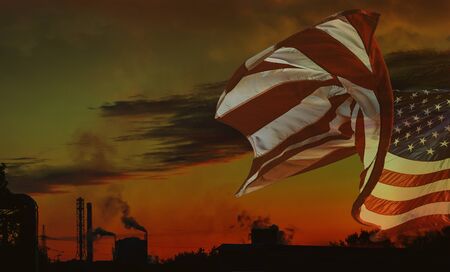 Industrial landscape - orange sunset over a working factory, smoke from the pipes makes purple clouds.の写真素材