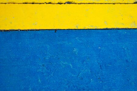 Background, texture - concrete wall, blue and yellow. Rough surface.の写真素材