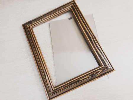 Frame of dark wood for needlework on a light background, horizontal photo