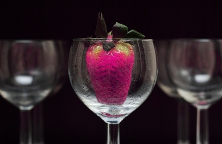 a glass on a black background with berry insideの写真素材