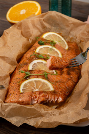 A piece of salmon cooked in the oven, baked in an orange marinade with lemon slicesの写真素材