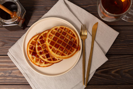 A portion of Viennese waffles on a plate with honey, dark keyの写真素材