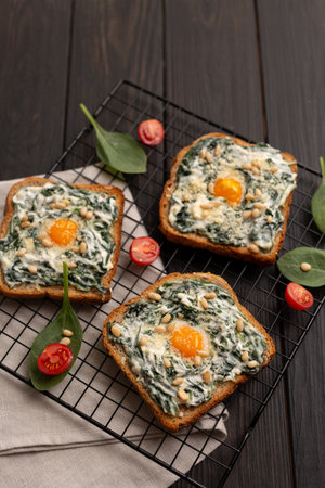 Toast with spinach, cream cheese and quail egg, pine nuts and cherry tomatoes