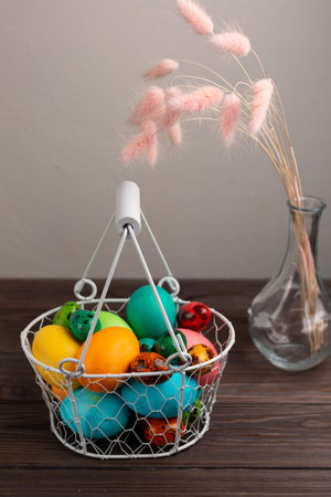 Painted multicolored eggs in a wicker white basketの写真素材