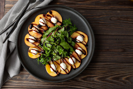 Italian summer Caprese salad with peach, Mozzarella balls, mixed salad and balsamic sauceの写真素材