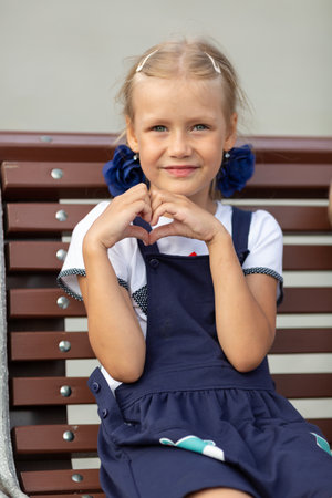 The girl shows the figure of the heart with her hands