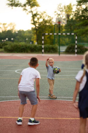 Little boy playing ball with friendsの写真素材