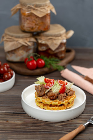 Turkey stew in glass jars, a portion of potato waffles with meat and vegetable saladの写真素材