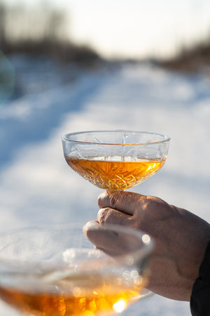 A man and a woman with glasses of champagne on a background of snow. Holiday concept, Christmas and...