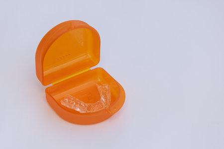 A splint for teeth to align the jaw in a storage box on a white background