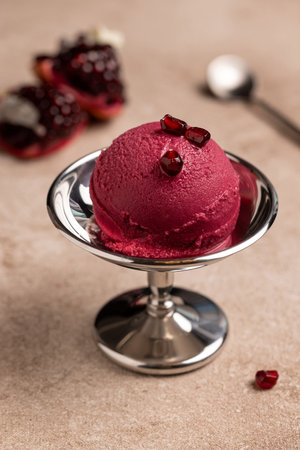 Pomegranate ice cream ball in metal creamerの写真素材