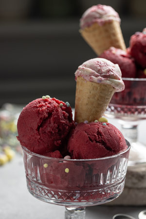 Red raspberry ice cream balls in a creamerの写真素材