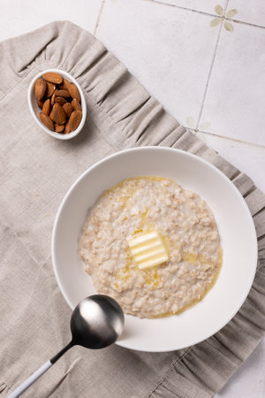 Oatmeal porridge with almond milk and a piece of butterの写真素材