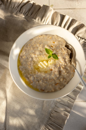 Oatmeal porridge with heart-shaped pieces of butterの写真素材