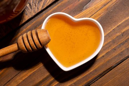 Fresh floral honey in a heart-shaped bowlの写真素材