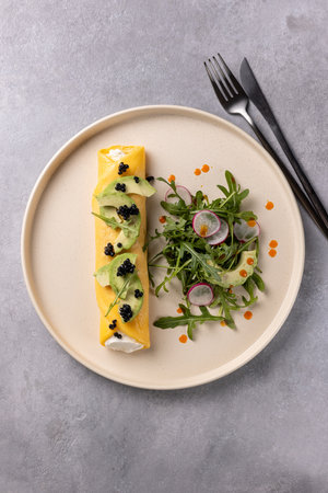 French omelette with ricotta and avocado, arugula and radish saladの写真素材