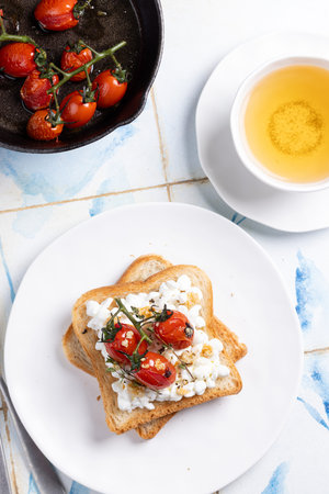 The photograph features a light homemade breakfast: two toasted slices of bread with cottage cheese,...