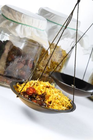 Scales measuring herbs symbolizing herbal and homeopathic pharmacy