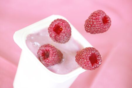 Ripe Raspberries Falling into Smoothie Yogurt Closeの写真素材