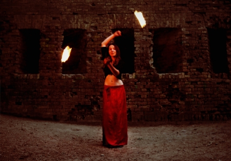 Young Girl Twisting Burning Poi on Fire Showの写真素材