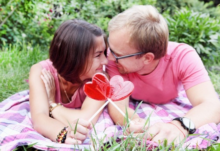 Young Couple Holding Candy Hearts on Picnicの写真素材
