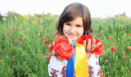 Smiling Girl Holding Wreath with Ukrainian Flag Yellow and Blue Ribbonsの写真素材