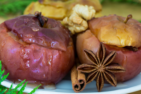 Baked apples with cinnamon and anise stars, stuffed with nuts and raisins, healthy food. Tasty christmas dessert. Close up. Macro.の写真素材