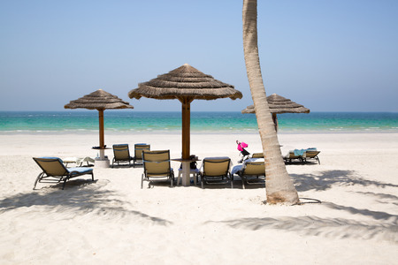 White sand beach, umbrellas, chair and turqouise water of Indean ocean, vacation and relaxing concept.の写真素材