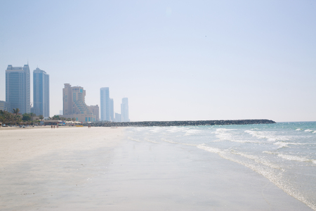 White sand beach, green ocean and high modern skyscrapers, Indian ocean, UAE.の写真素材