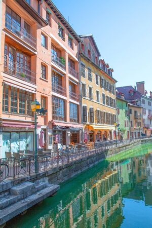 Annecy downtown. Beautful green channel, a lot of cafe and restaurante. Colorful facades of old buildings. France. Buildings reflect in the water.の写真素材