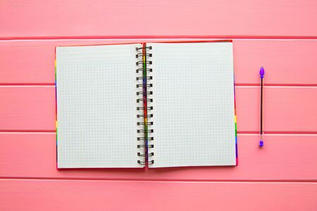 A blank open notebook and pen on pink background, top view. Writing a list, future plans concept.の写真素材